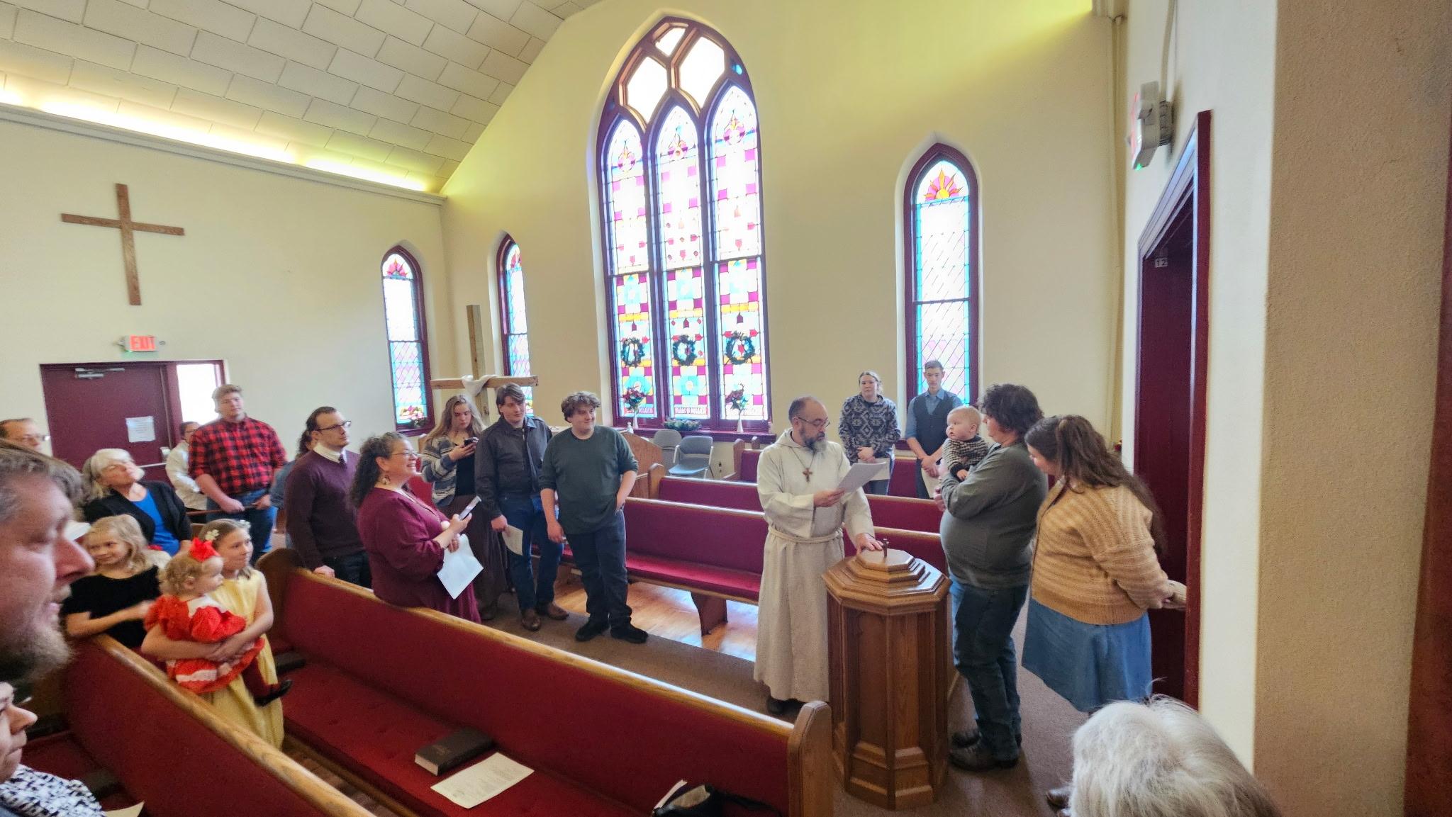 Church members gathered around the baptismal font